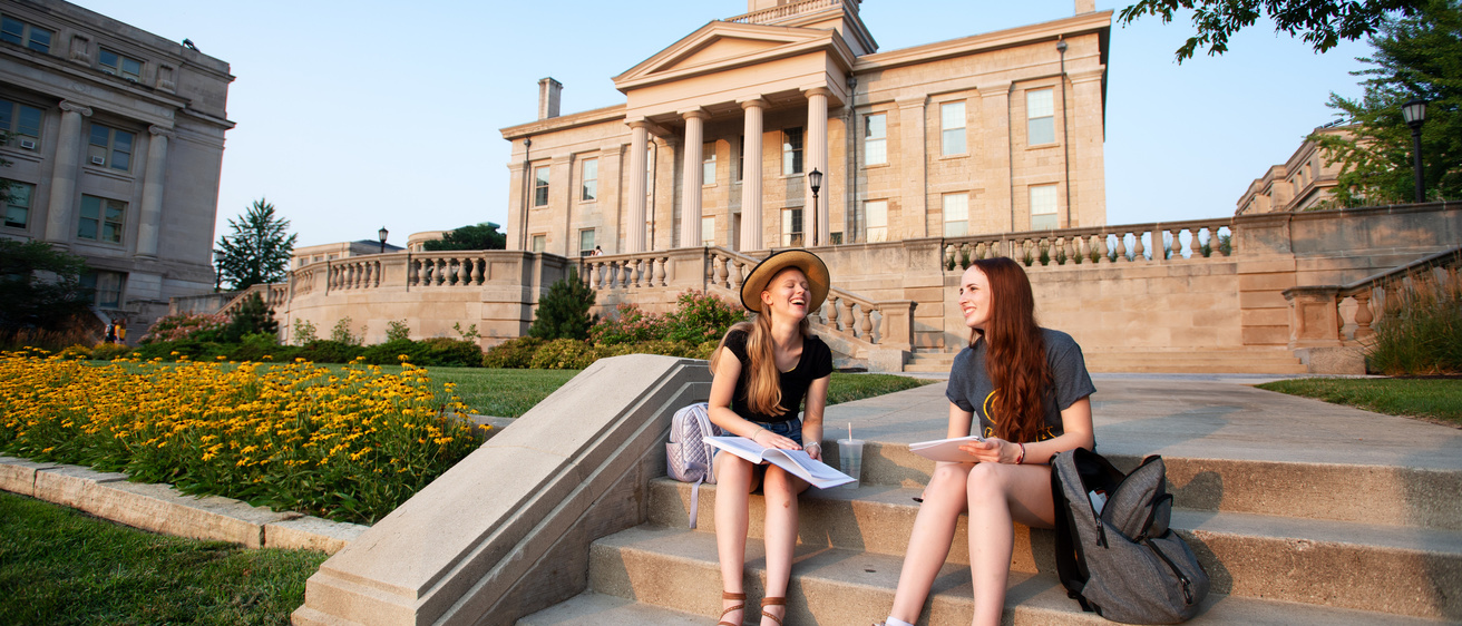 Students sitting together on the steps near the Old Cap