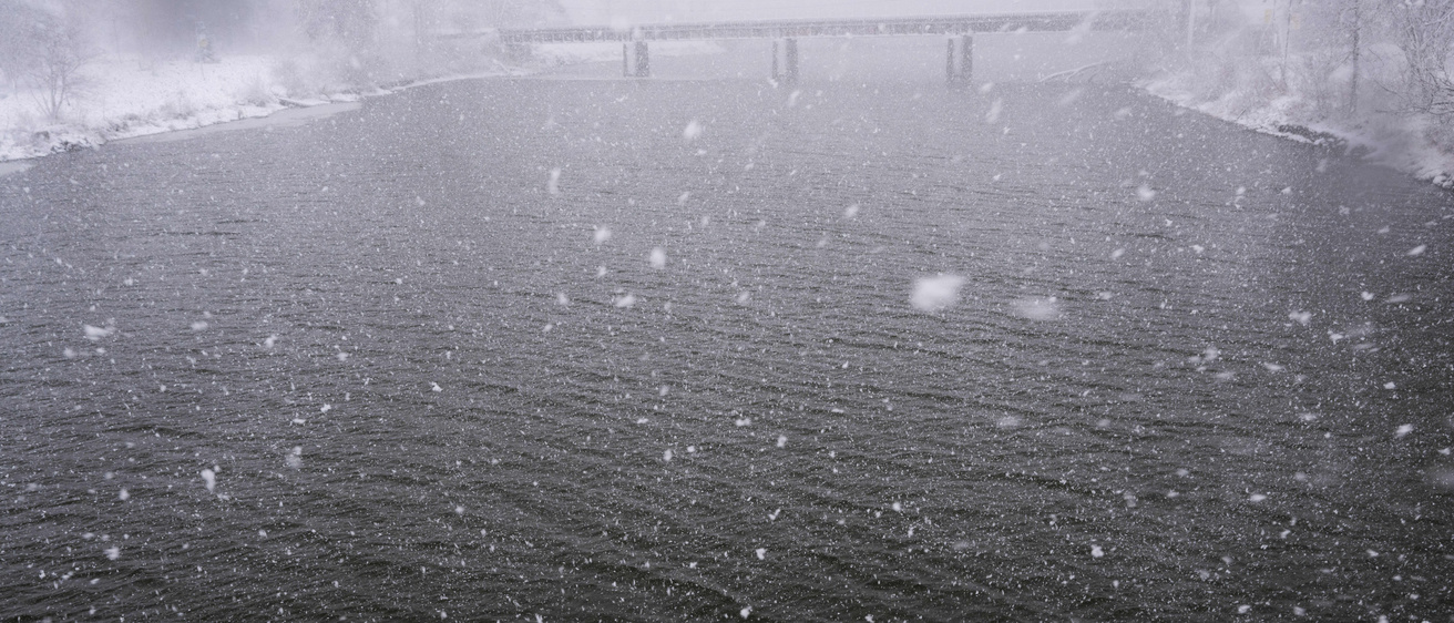 Light snow falling on the river