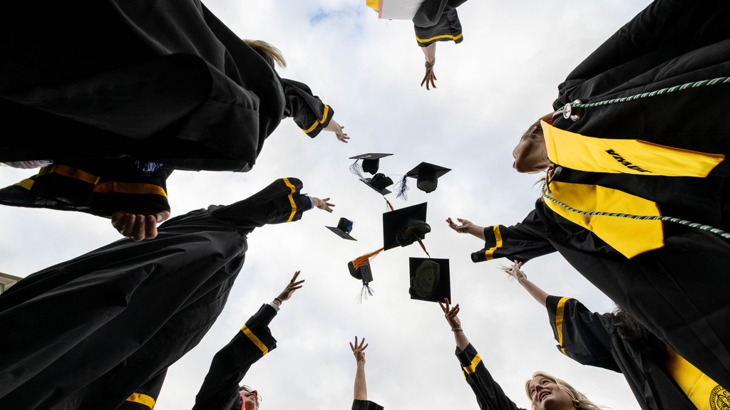 Graduates throwing caps in air from ground view